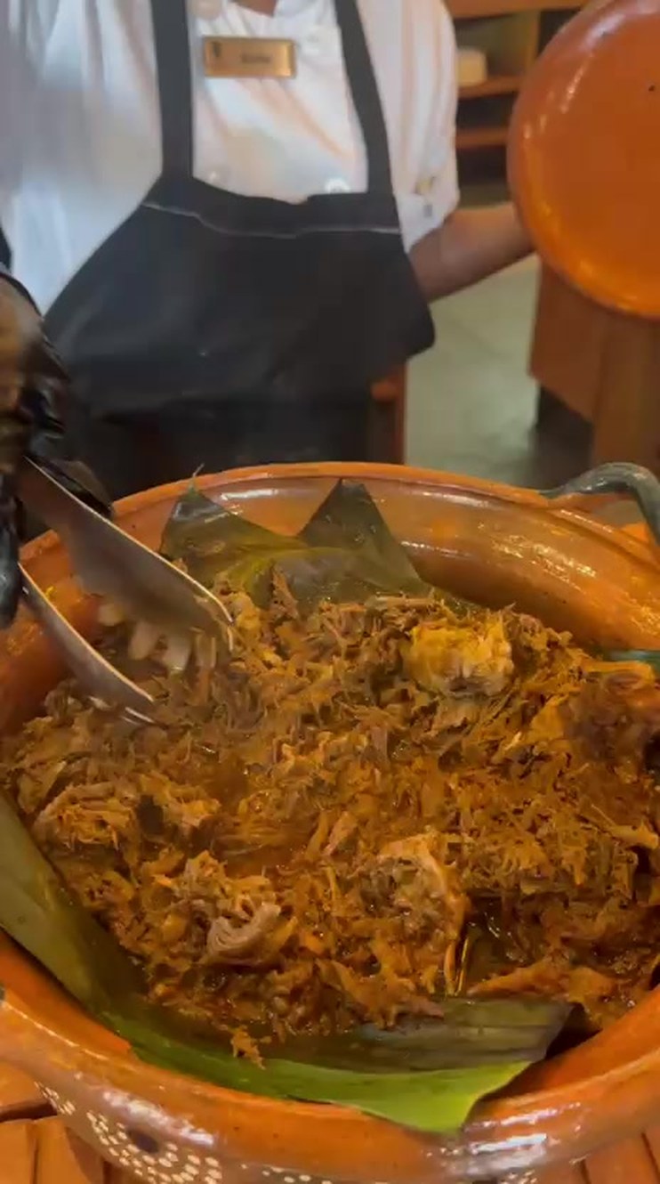 Cochinita in a clay pot beside a comal of fresh tortillas at the Oriente breakfast station