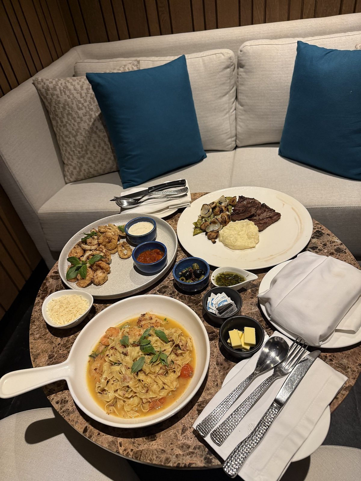 In-villa dining: calamari, shrimp pasta and skirt steak set on a low table