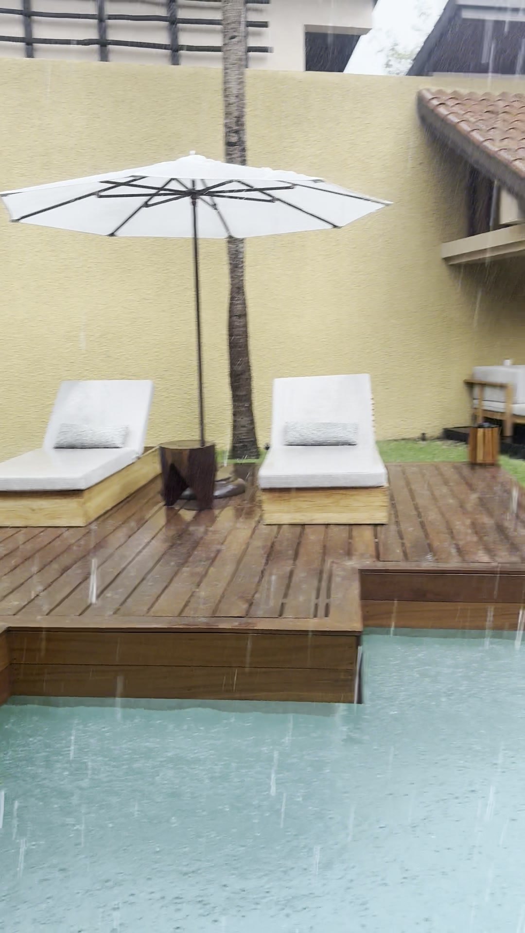 Heavy rain falling on the private pool, teak deck and loungers of a Bliss Pool Villa at Banyan Tree Mayakoba