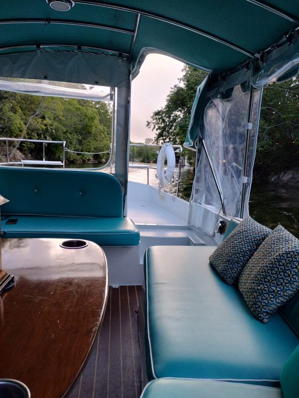 Interior of a covered boat on a mangrove-lined canal at Mayakoba