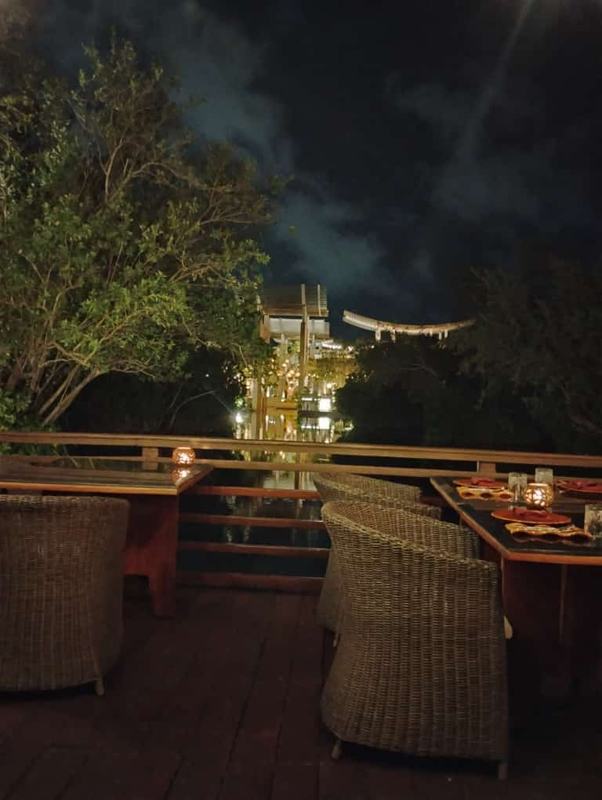 Evening terrace at Mayakoba overlooking a lit walkway across the water