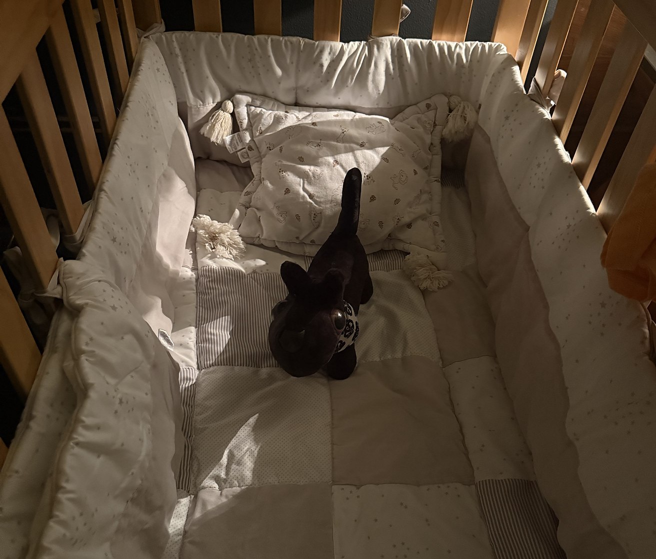 The crib, made up and waiting, with someone already in it.